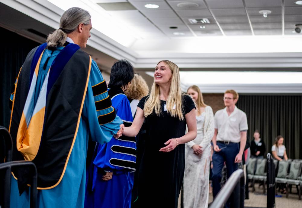 Student shaking hand with faculty 1